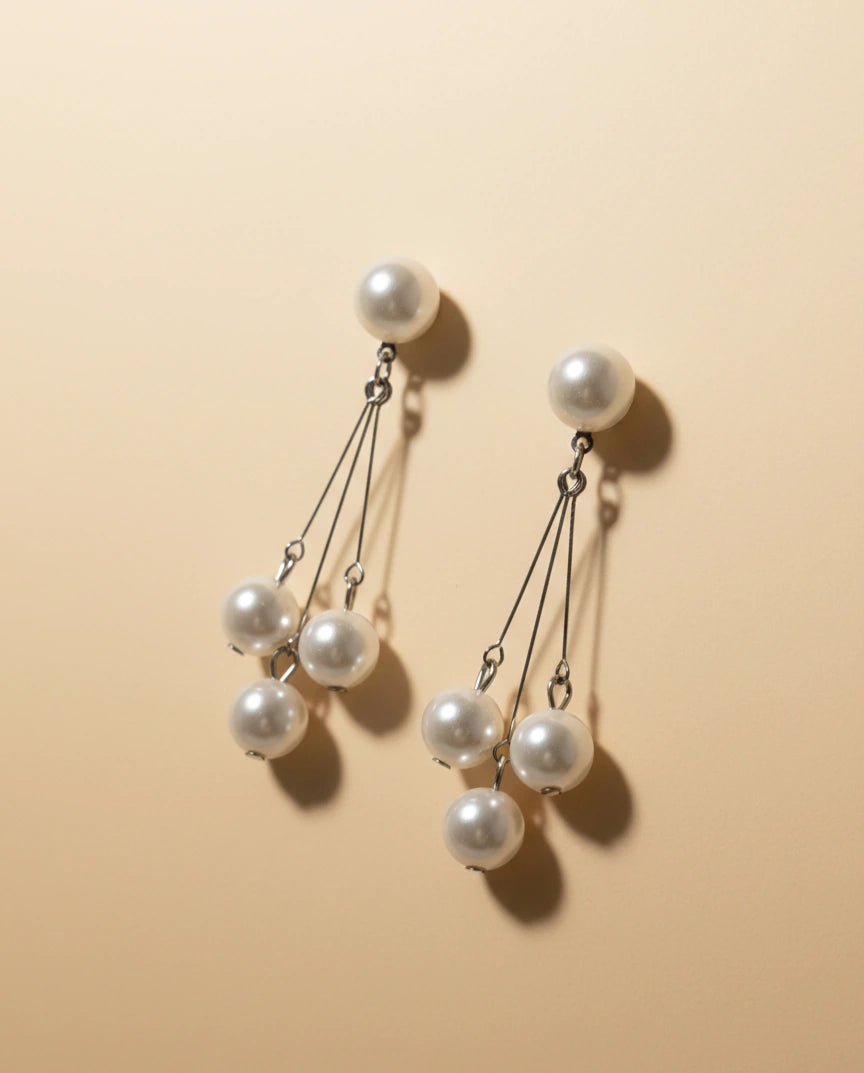 Pearl earrings on a beige background