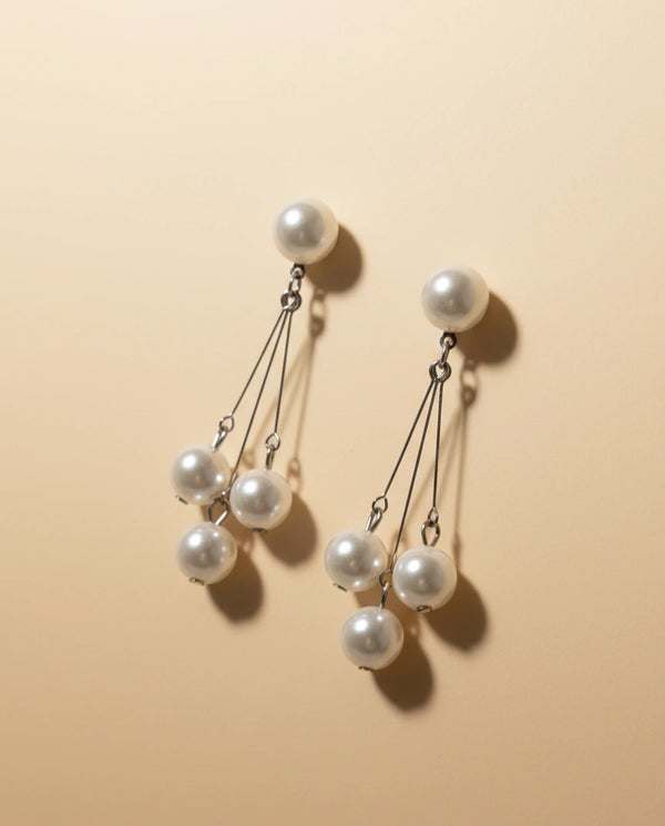 Pearl earrings on a beige background
