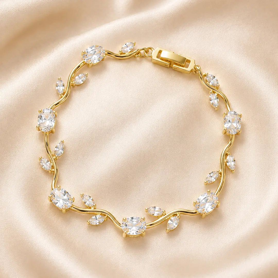 Gold bracelet with clear stones on a beige satin background